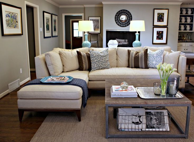 Love this lighter tan/neutral sectional. Blue accent lamps on a couch table behind link to the dark blue throw pillows, restoration hardware / industrial coffee table, neutral colored rug, nice large uniform picture frames as wall art, average sized living room, small living room, under techie coffee table magazines